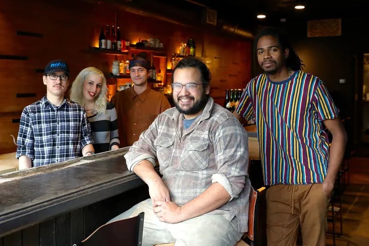James Mark (center) sits at the bar in his restaurant Big King, along with cooks (from left) Oscar Lange, Emily Joslyn, Peter Kachmarsky, and JC Kuvaszko. Mark employs fewer than 50 people, so he isn't required to provide health benefits, but he does anyway because he thinks it helps with staff retention and is the right thing to do.