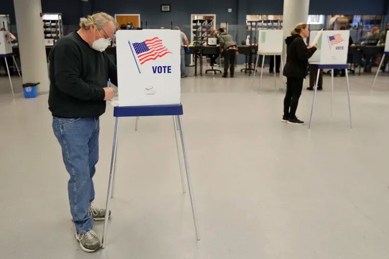 Jerome Fedor, left, voting using social distancing at the Cuyahoga County Board of Elections, in April in Cleveland.