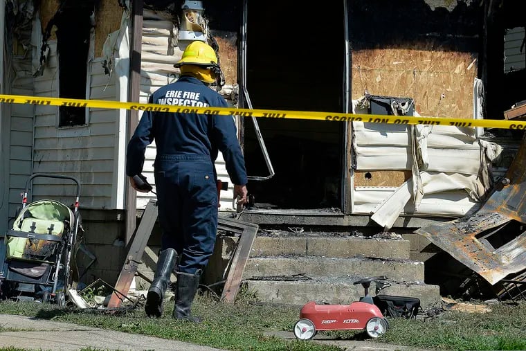 Erie Bureau of Fire Inspector Mark Polanski helps investigate a fatal fire at 1248 West 11th St. in Erie, Pa, on Sunday, Aug. 11, 2019. Authorities say an early morning fire in northwestern Pennsylvania claimed the lives of multiple children and sent another person to the hospital.