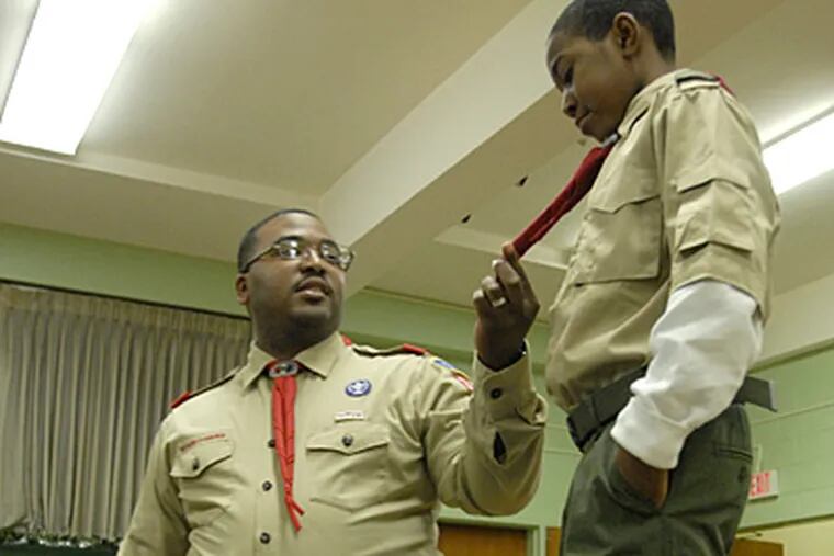 Scoutmaster Brian Wallace inspects the uniform of Marcus Harris in preparation for next month’s presidential inaugural parade. (Jonathan Wilson / Staff Photographer)