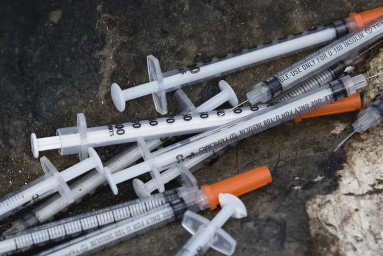 This July 31, 2017, file photo shows discarded syringes in an open-air heroin market that has thrived for decades, slated for cleanup along train tracks a few miles outside the heart of Philadelphia. Philadelphia wants to become the first U.S. city to allow supervised drug injection sites as a way to combat the opioid epidemic, city officials announced Tuesday, Jan. 23, 2018, saying they would seek outside operators to establish one or more safe injection sites.