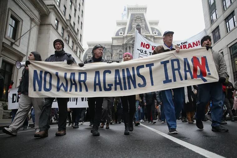 People hold a banner as they lead a march against a potential war against Iran in Center City Philadelphia on Saturday, Jan. 4, 2020. Several hundred people attended the protest, organized after President Donald Trump approved an airstrike that killed a powerful Iranian general this week.