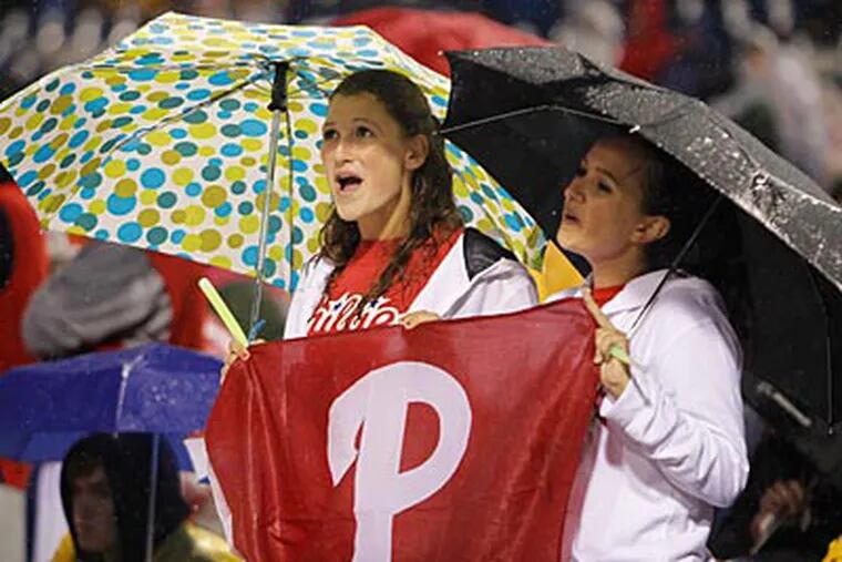 The rain didn't bother these two fans Tuesday night at the Phillies' 6-3 victory. (Ron Cortes/Staff Photographer)