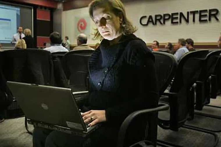 Kirsten Haas, commercial operations manager at Carpenter Technology Corp. in Reading, works on a laptop computer during an online webinar with out-of-town employees. Many companies are cutting back on company travel.  (Laurence Kesterson / Staff Photographer)