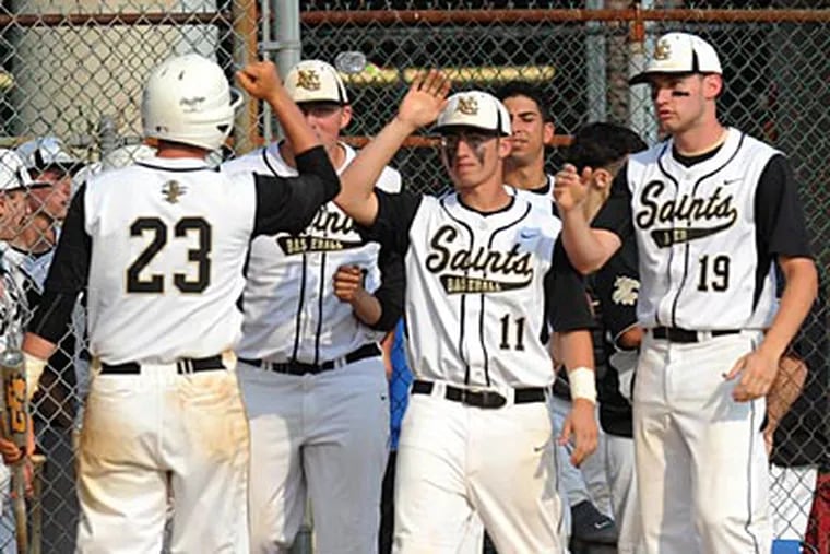 Neumann-Goretti players celebrate their 10-run win in the bottom of the fifth. (Sarah J. Glover/Staff Photographer)