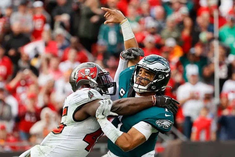 Eagles quarterback Jalen Hurts getting hit by Tampa Bay Buccaneers inside linebacker Devin White during the third quarter Sunday.