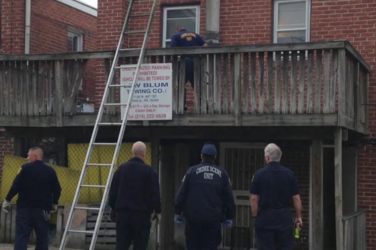 Police investigate the site of a May 6, 2013 home invasion on Castor Ave. in Northeast Philly that left a 74-year-old woman dead and a man hospitalized. (Emily Babay/ Staff)