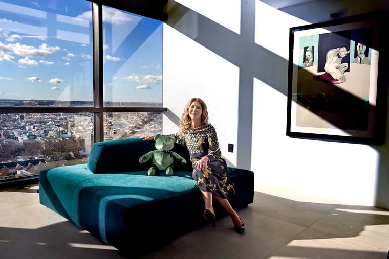 Natasha Vana poses in the living room / den with a view facing south in her two-story condo on Washington Square Wednesday, Jan. 10, 2024.