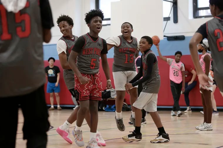 Quader Brown-Wilson (5) is surrounded by happy teammates after his free throws at the end of a game gave his team a victory in the Penn-West Philadelphia Basketball League at Lea Elementary School.