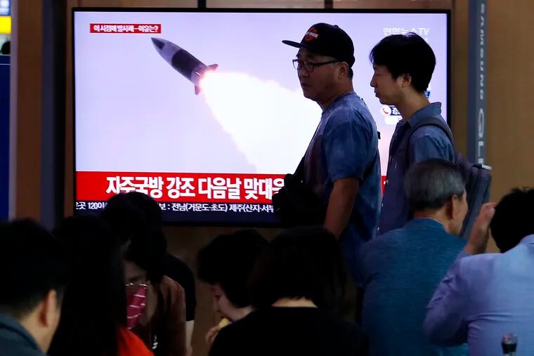 People pass by a TV showing a file image of North Korea's missile launch during a news program at the Seoul Railway Station in Seoul, South Korea, Wednesday, Oct. 2, 2019.