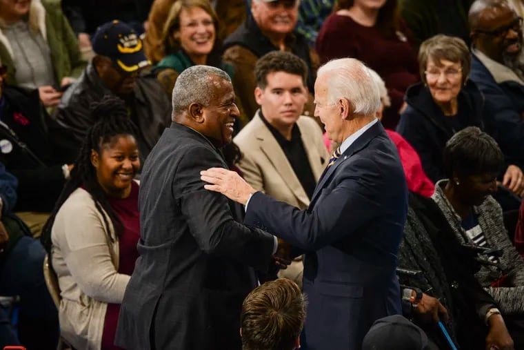 Democratic presidential candidate Joe Biden shakes hands and embraces an audience member during a town hall event in Greenwood, S.C., on Nov. 21.