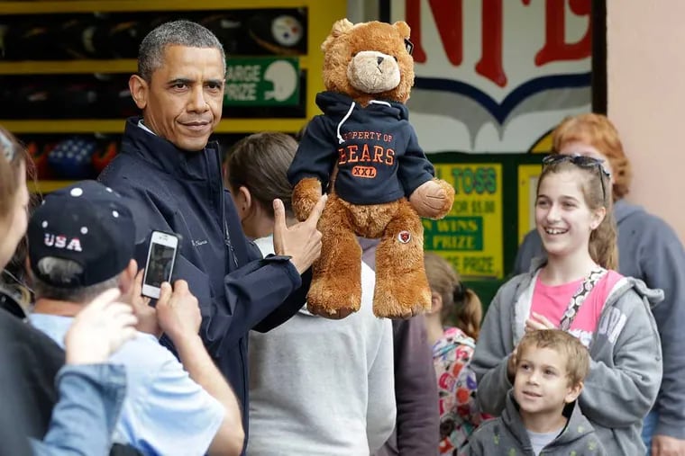 President Barack Obama holds up a stuffed bear that New Jersey Gov. Chris Christie, not shown, had won tossing a football after playing the 'Touchdown Fever' game on the boardwalk during their visit to Point Pleasant, NJ., Tuesday, May 28, 2013.  Obama traveled to New Jersey to join Christie to inspect and tour the Jersey Shore's recovery efforts from Hurricane Sandy. (AP Photo/Pablo Martinez Monsivais)