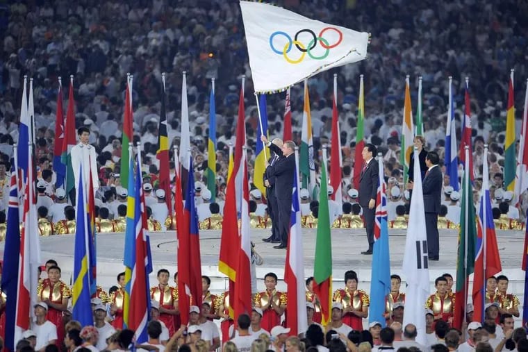 Athletes wave the Olympic flag at the closing ceremony in Beijing in &mdash; no, you have to guess the year below. VICTOR FRAILE / BPI via Bloomberg News