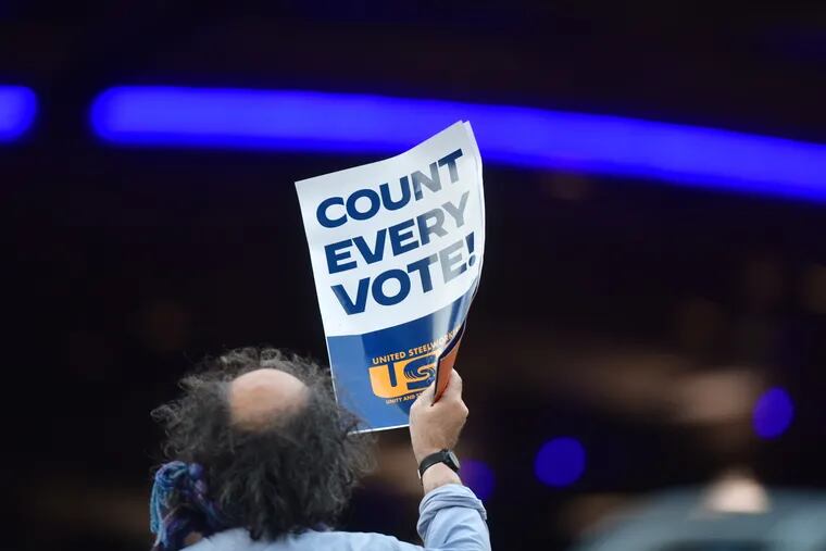 A man holds a placard that reads "Count Every Note" while demonstrating across the street from supporters of President Donald Trump outside of where votes are still being counted, six days after the general election on Nov. 9, 2020 in Philadelphia, Pennsylvania.  The state was called for President-elect Joe Biden on Saturday, propelling him past the requisite 270 electoral votes to win the presidency.