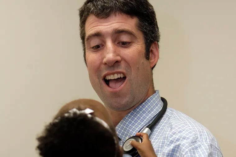 Pediatrician Daniel Taylor holds one of his patients at St. Christopher's Children's Hospital.