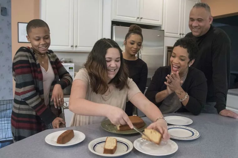 Audelia Crabbe cuts her cake on her 14th birthday with her adoptive family (from left) Nacera Wynn, Billie Walker, Valerie Crabbe and Larry Harris.