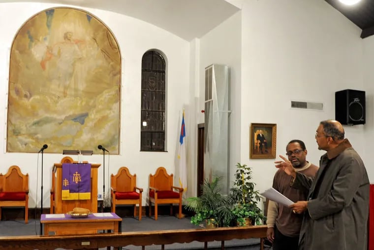 In the sanctuary at Mount Carmel Holy Church , Michael Benson (left), one of the pastors, listens to Alfred J. Dansbury Sr. talk about his research on artist H. Willard Ortlip and the Second Coming painting at left.
