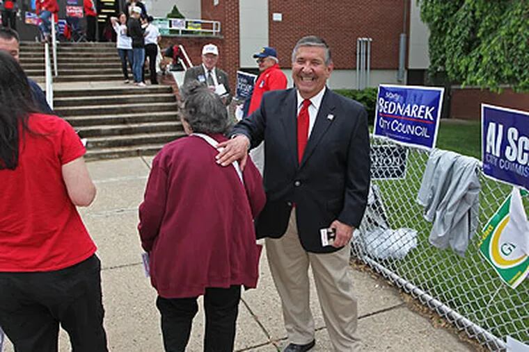 Philadelphia City Councilman Frank Rizzo Jr. shares a laugh with a voter going into Robert Pollack School to cast her ballot in the primary election Tuesday. (Michael Bryant / Staff Photographer)