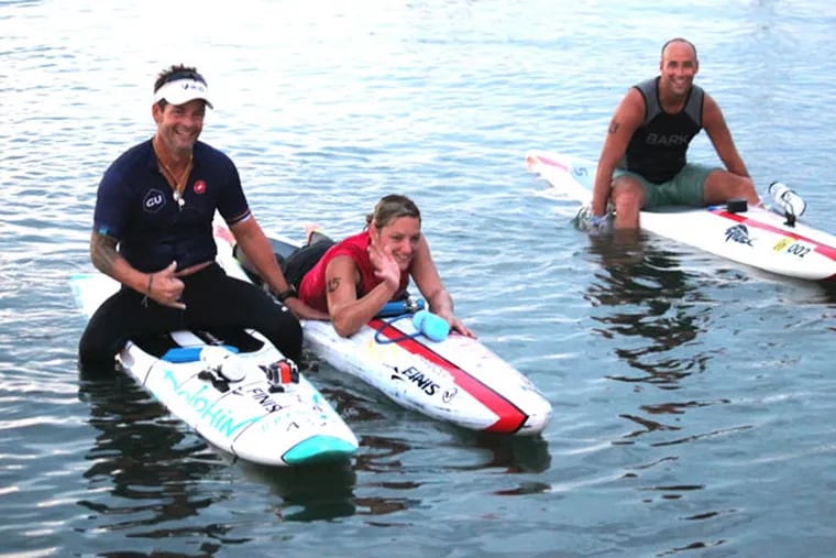 Paraplegic athlete Dawn Robinson with her trainer Bruckner Chase (left) and paddler Dave Allison as she completed the Upper Township Beach Patrol 5 mile paddle board race in Strathmere on July 27.
(Photo courtesy of Jeffrey G. Barnes)