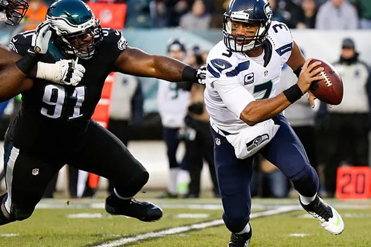 Seattle Seahawks quarterback Russell Wilson (3) eludes the pass rush of Philadelphia Eagles defensive end Fletcher Cox (91) during the first quarter at Lincoln Financial Field. (Bill Streicher/USA Today)