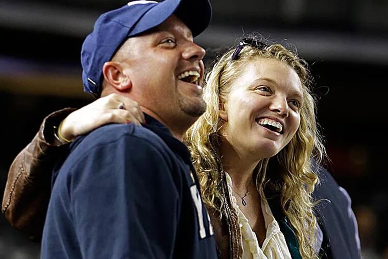Two fans embrace while singing "Sweet Caroline" as a tribute to the victims of the Boston Marathon explosions after the third inning. (Kathy Willens/AP)
