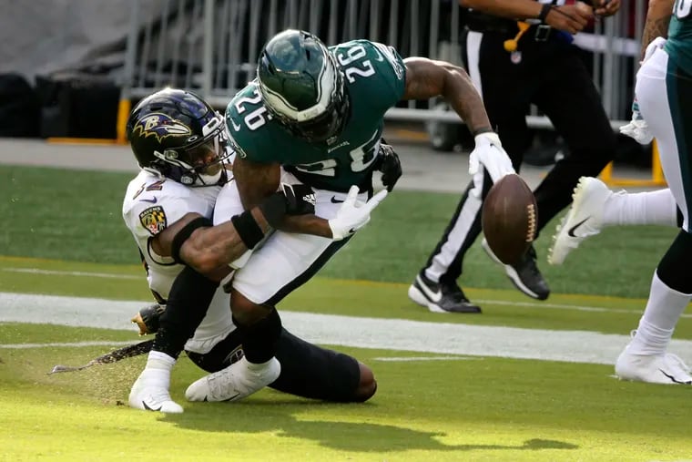 Ravens free safety DeShon Elliott knocks the ball out of Eagles running back Miles Sanders' hands during the third quarter of Sunday's 30-28 loss.