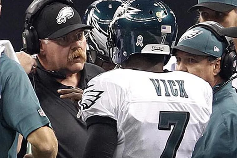 Eagles head coach Andy Reid talks to quarterback Michael Vick during the team's game against the Saints. (Ron Cortes/Staff Photographer)