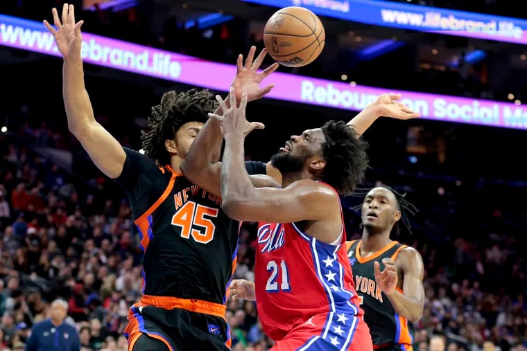 Joel Embiid of the Sixers loses the ball as he gets fouled by Jericho Sims of the Knicks during the first half of their game at the Wells Fargo Center on Feb. 10, 2023.
