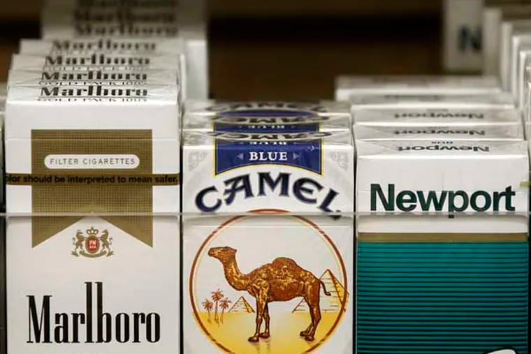 Pictured are packs of cigarettes waiting to be purchased at a news stand Friday, Nov. 30, 2012. (AP Photo/Charles Rex Arbogast)
