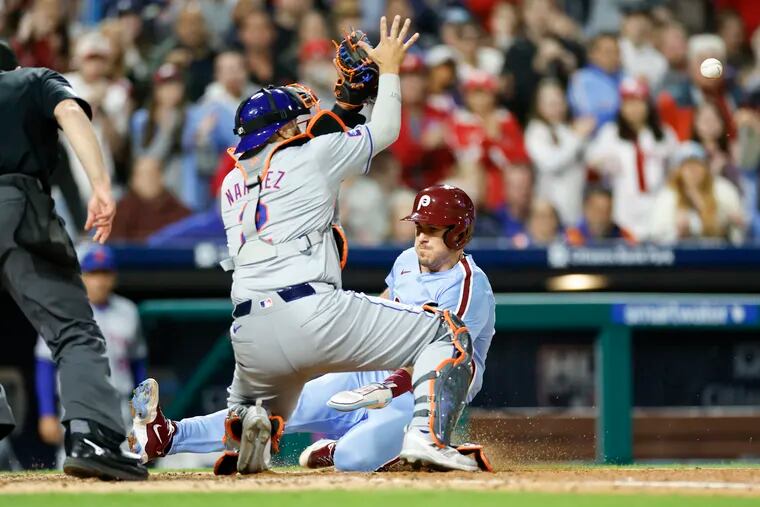 Phillies J.T. Realmuto scores past New York Mets catcher Omar Narvaez in the sixth inning.