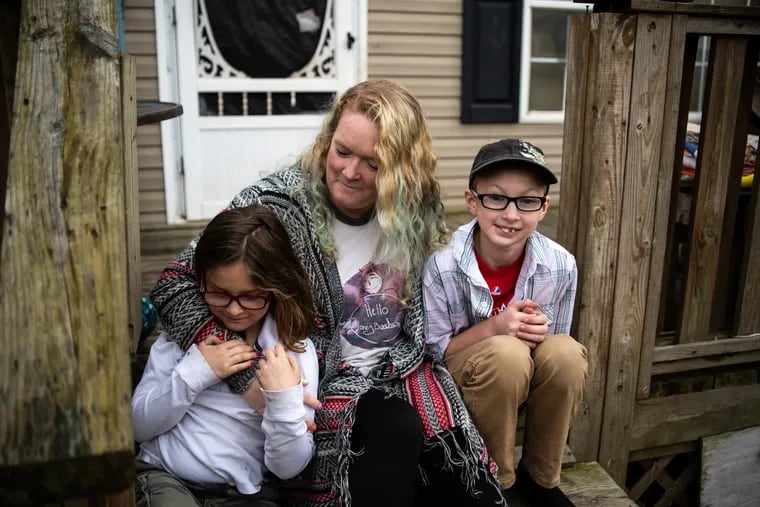 Renae Shultz sits on the porch of her home with her daughter Delilah (left) and son Kaiden (right) in Honey Brook, Chester County. Shultz and her family are struggling to afford food as prices rise due to inflation.