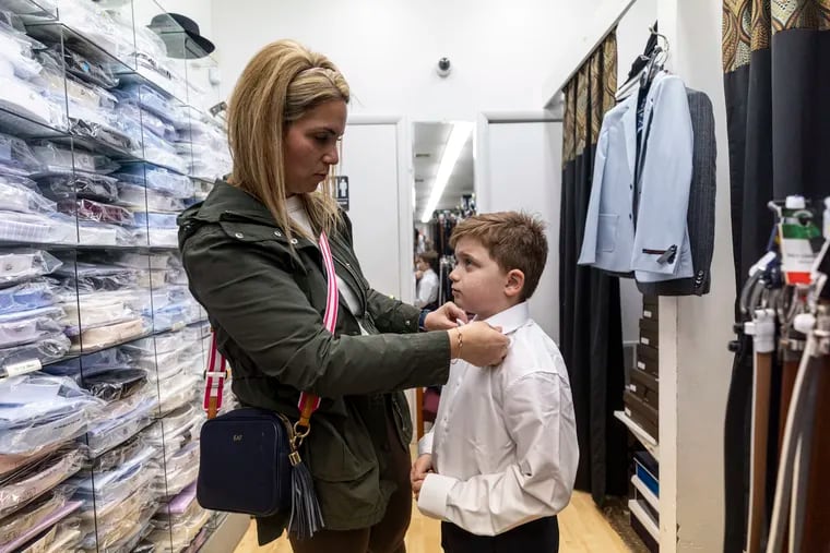 Henry Franchi, 8, of Washington Township, N.J., is wearing a navy communion suit and a white bow tie put on by his mom Ellenmarie Franchi, at Goldstein's Clothing in Philadelphia, Pa., on Saturday, March 9, 2024.