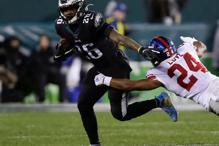 Eagles running back Miles Sanders tries to escape the grasp of Giants cornerback Julian Love on Dec. 9.