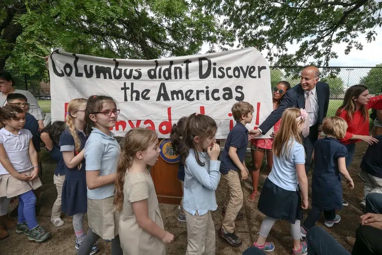 Councilman Mark Squilla, right, in blue suit, thanks children from the Christopher Columbus Carter School at the groundbreaking ceremony for a $2.5 million renovation project at Columbus Square park. Demonstrators held up a large banner during the event in South Philadelphia.