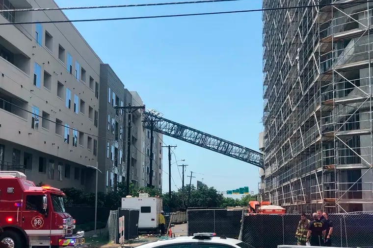 Officials respond to the scene after a crane collapsed into Elan City Lights apartments in Dallas amid severe thunderstorms Sunday, June 9, 2019. (Michael Santana via AP)