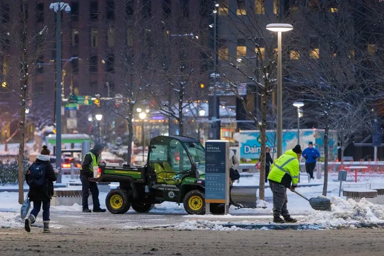 Park and Recreation employees removing snow from around LOVE Park at 15th and JFK Blvd in Center City on Tuesday.