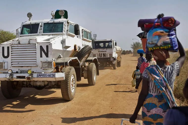 A United Nations vehicle passes people making their way to a U.N. shelter in Malakal, South Sudan. (Ben Curtis / AP)