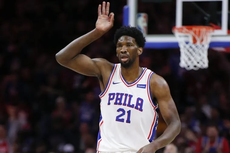 Sixers center Joel Embiid raises his hand after making a three-point basket against the Golden State Warriors on Saturday.