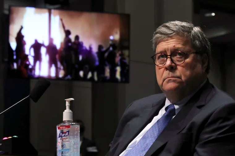 Attorney General William Barr listens during a House Judiciary Committee hearing on the oversight of the Department of Justice as a video plays in the background Tuesday.