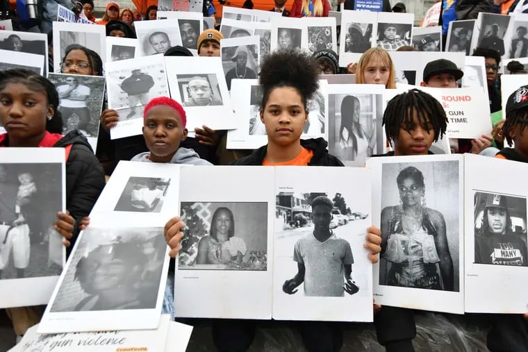 Students from Philadelphia hold photos of gun violence victims at a rally at the Pennsylvania Capitol pressing for stronger gun control laws, Thursday, March 23, 2023, in Harrisburg.
