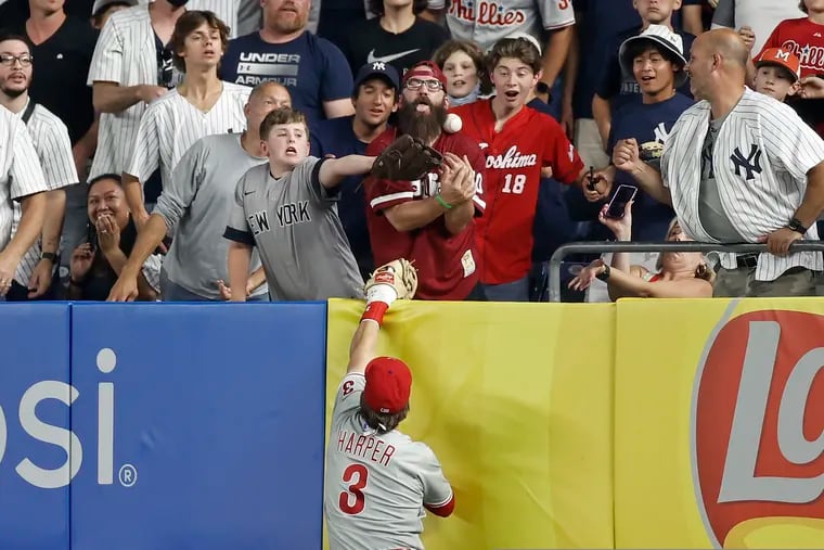 Phillies right fielder Bryce Harper can't get to a home run hit by the New York Yankees' Brett Gardner that just cleared the right-field wall Tuesday night at Yankee Stadium. The Phillies lost the game, 6-4.