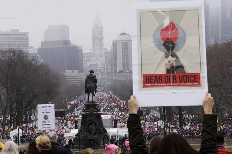 Belinda Chew of Phila. stands on Art Museum steps with her message during the Philadelphia segment of the National Women's March on the Benjamin Franklin Parkway in Philadelphia on Jan. 21, 2017.