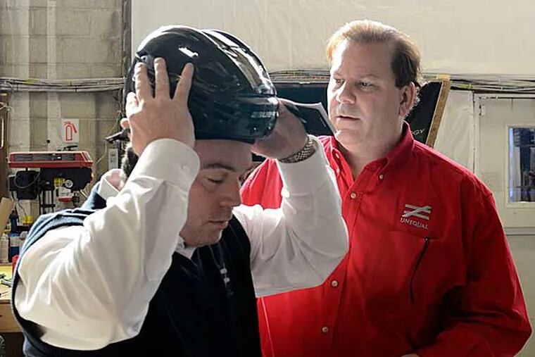 Robert A. Vito (right) president, and Michael Foerster (left) VP for research and product development, check out the padding in a hockey helmet at Unequal Technologies in Oxford, PA December 14, 2012, one of the many concussion-related industrues that this epidemic has spawned. (Tom Garlish/Staff Photographer)