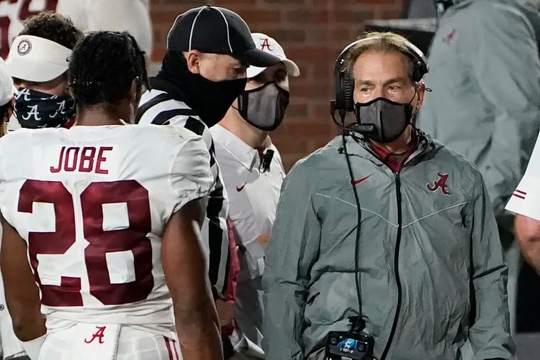 Alabama football head coach Nick Saban, right, wearing a mask on the sideline during a recent game.