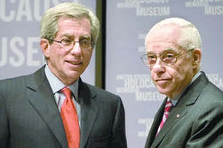 Fred S. Zeidman (left) of the Holocaust Memorial receives transcripts from Mukasey.