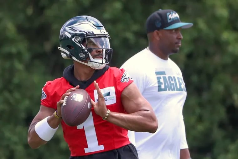 Eagles’ quarterback Jalen Hurts (1) throws the ball next to quarterback coach Brian Johnson during OTAs at the NovaCare Complex in Philadelphia on Wednesday, June 8, 2022.