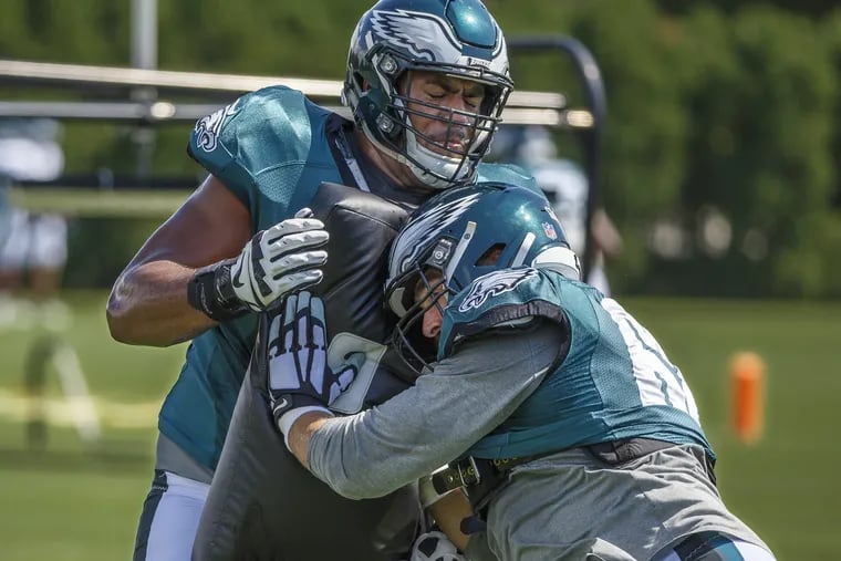 Eagle offensive lineman, #68 Jordan Mailata, left, holds the blocking pad and provides resistance to fellow lineman #62, Jason Kelce, right, during Sunday's practice at the NovaCare Center on September 2, 2018. MICHAEL BRYANT / Staff Photographer