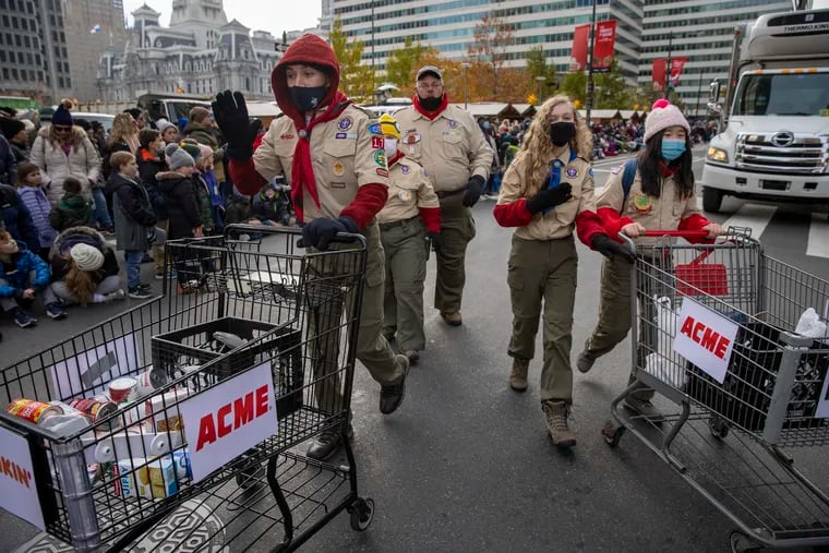Members of the Boy Scouts, collect food for Philabundance during the Thanksgiving Day Parade through Center City Philadelphia on November 25, 2021.