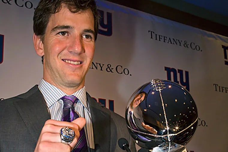 New York Giants quarterback Eli Manning poses with his Super Bowl XLVI ring. (AP Photo/John Minchillo)