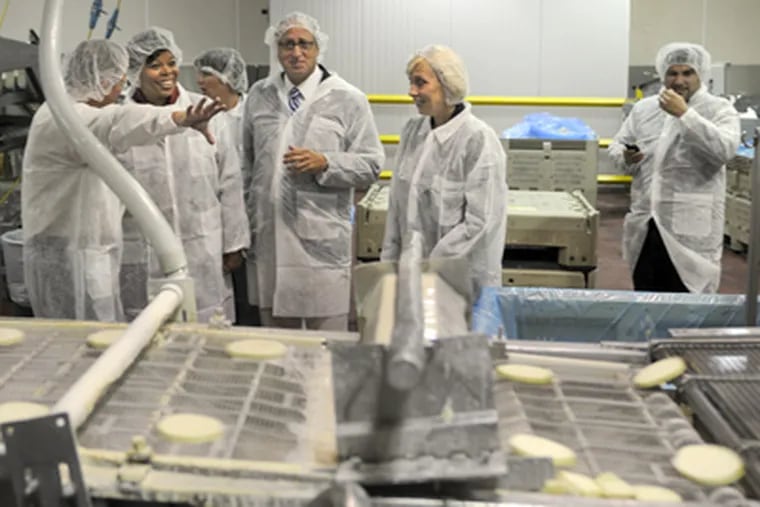 Lt. Gov. Kim Guadagno (center right), Camden Mayor Dana L. Redd (second from left), and Comarco Products co-owner Tom Hoversen (far left) tour Comarco's Camden plant. (Tom Gralish / Staff Photographer)